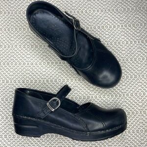 Dansko black clogs with buckled strap.